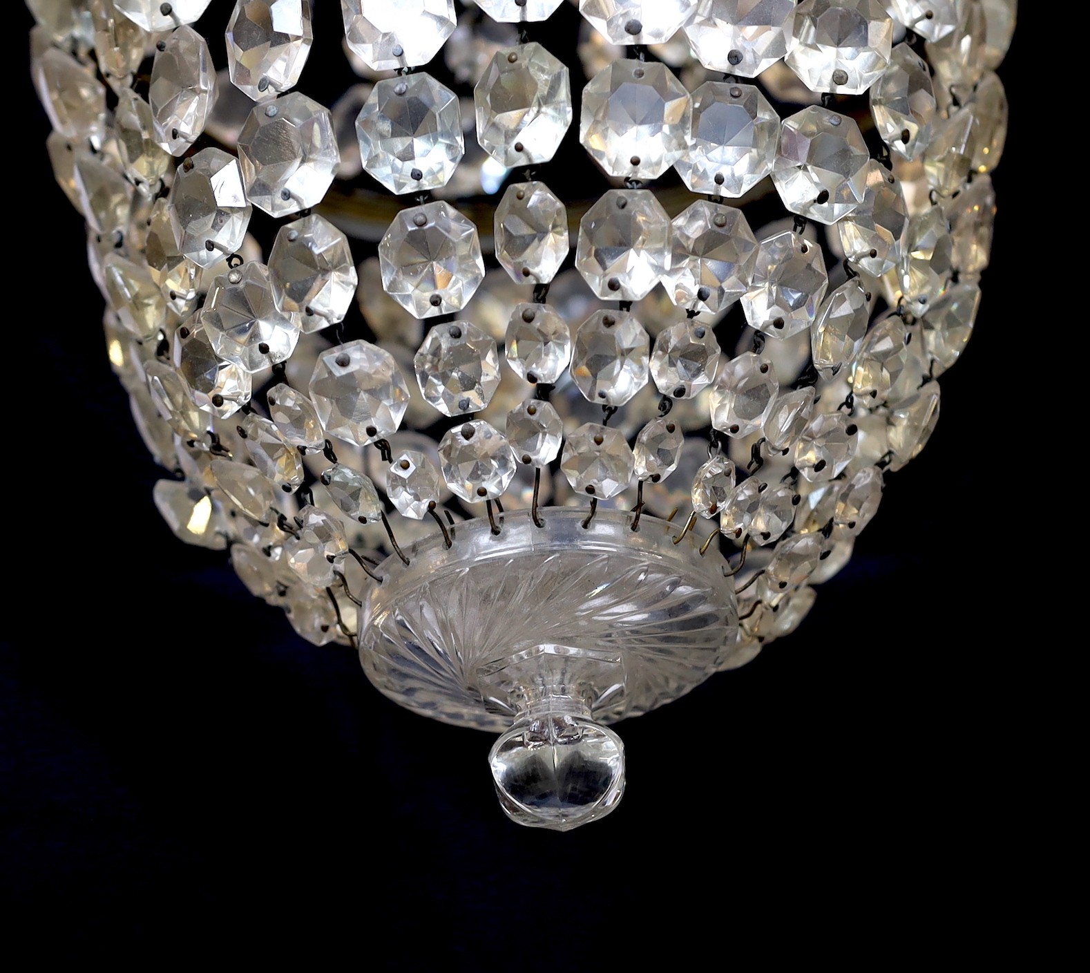 An early 20th century bronze and beaded crystal bag shaped chandelier with graduated octagonal cut drops, height 50cm. width 30 cm